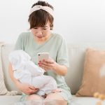 赤ちゃんを抱えながら予約する女性