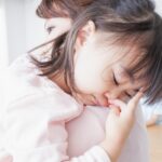 ママに抱かれて寝る子供